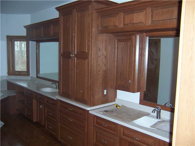 Red oak cabinets - Raised panel doors and drawer fronts - Full overlay style - Corian solid surface countertops with integral sinks