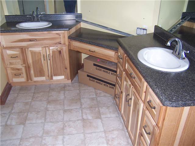 Rustic hickory cabinets - Flat panel doors and drawer fronts - Standard overlay style - Laminate countertops with drop-in sinks