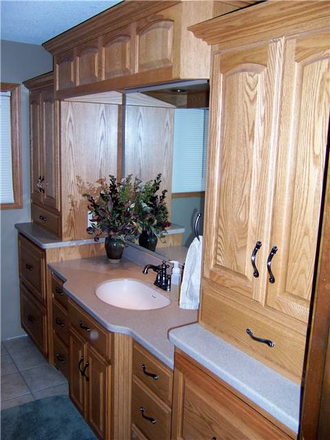 Red oak cabinets - Raised panel doors - Standard overlay style - Corian solid surface countertops with an integral sink