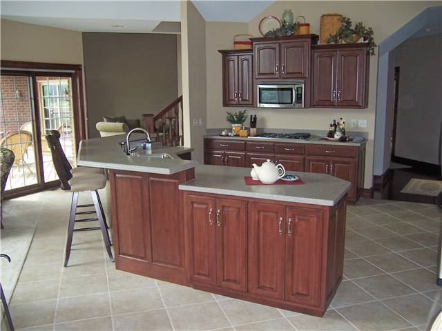 Hickory cabinets - Island with raised bar - Raised panel doors - Standard overlay style - Corian solid surface countertops