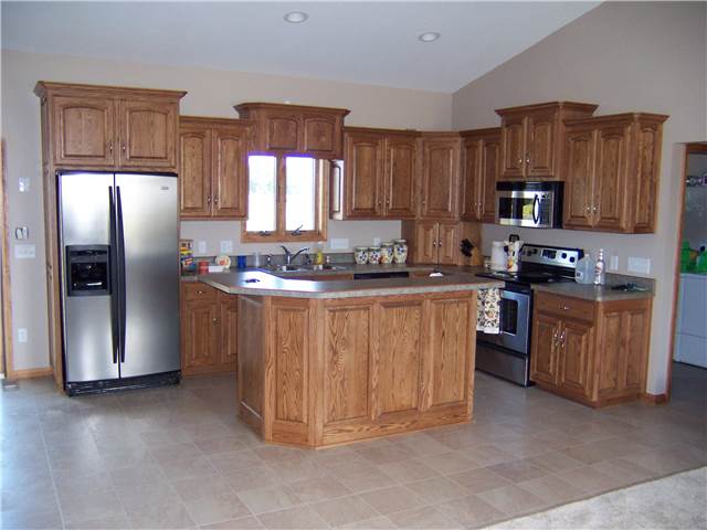 Red oak cabinets - Island with raised bar - Raised panel doors and side panels - Standard overlay style - Laminate countertops
