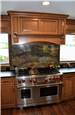 Stained and glazed maple cabinets - commercial range - commercial wood range hood - granite countertop and backsplash