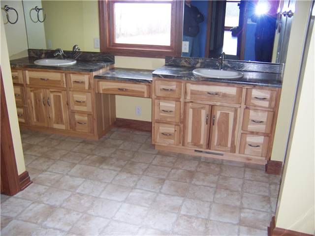 Rustic hickory cabinets - Flat panel doors and drawer fronts - Standard overlay style - Laminate countertops with drop-in sinks