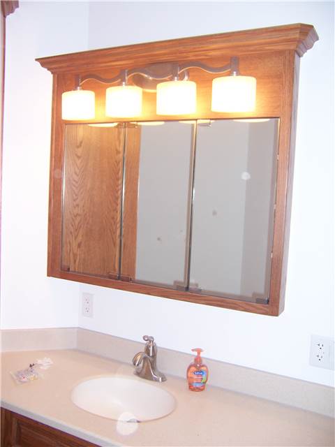 Red oak medicine cabinet with mirror doors - Corian solid surface countertop with integral sink