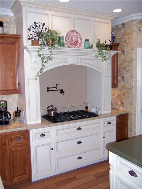 Cooking area featuring a painted wood cooking enclosure with an exhaust hood