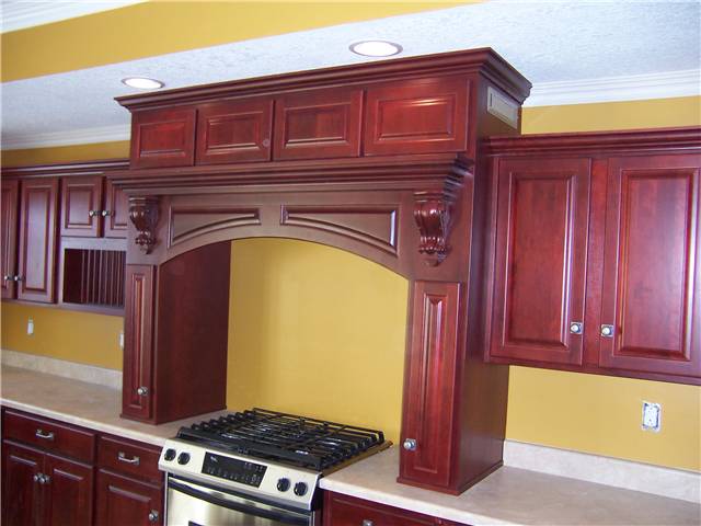 Wood cooking enclosure with an exhaust hood